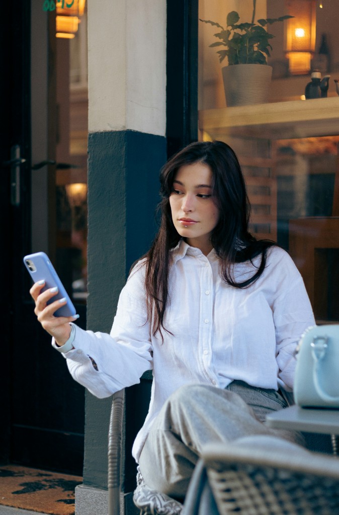 Young woman using her smartphone at an outdoor café